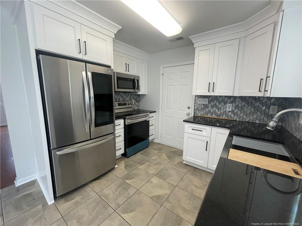 2239 Gray Goose Loop Fayetteville, NC 28306 - Photo 6 of 26 a kitchen with stainless steel appliances granite countertop a refrigerator a stove a sink and a microwave