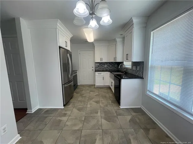 a kitchen with stainless steel appliances granite countertop a refrigerator a sink and dishwasher
