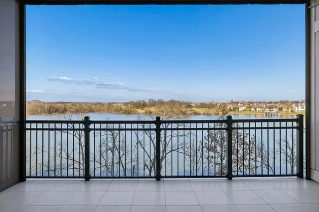 a kitchen with stainless steel appliances kitchen island granite countertop a wooden floor and white cabinets