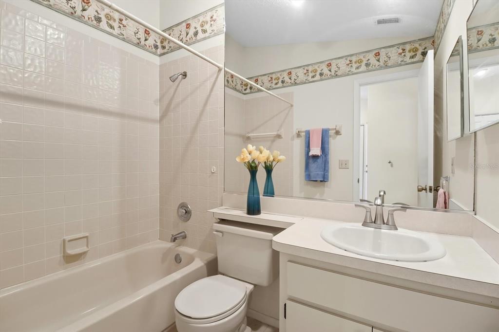 9470 Nakoma Way Weeki Wachee, FL 34613 - Photo 19 of 45 a bathroom with a sink a toilet a mirror a vanity and shower