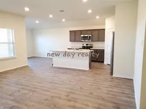 a view of kitchen with stainless steel appliances kitchen island sink stove and refrigerator