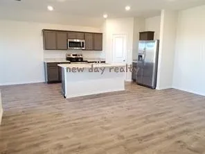 a large kitchen with stainless steel appliances a refrigerator stove microwave and sink