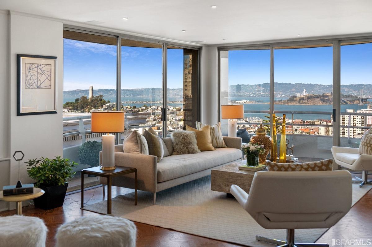 a living room with furniture city view and large windows