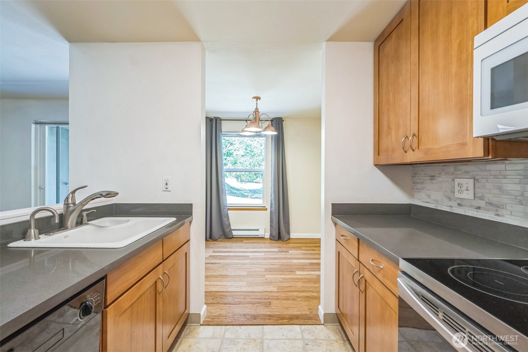 7311 224th Street Southwest, Unit C5 Edmonds, WA 98026 - Photo 12 of 28 a kitchen with granite countertop a sink stove and cabinets