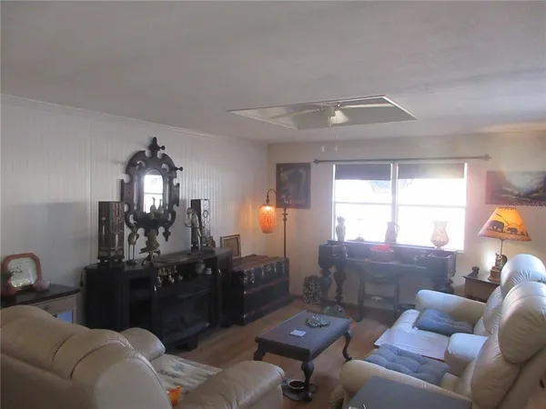 a view of a hallway with wooden floor and a livingroom