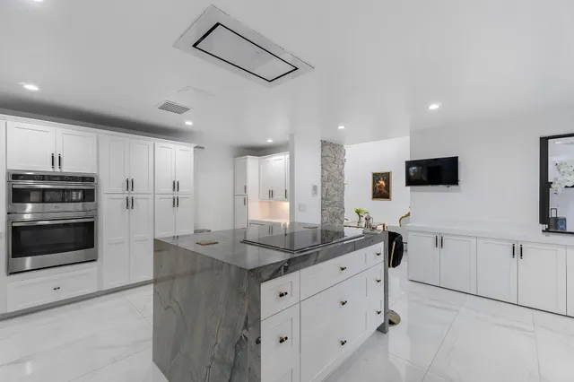 a kitchen with stainless steel appliances kitchen island granite countertop a sink and cabinets