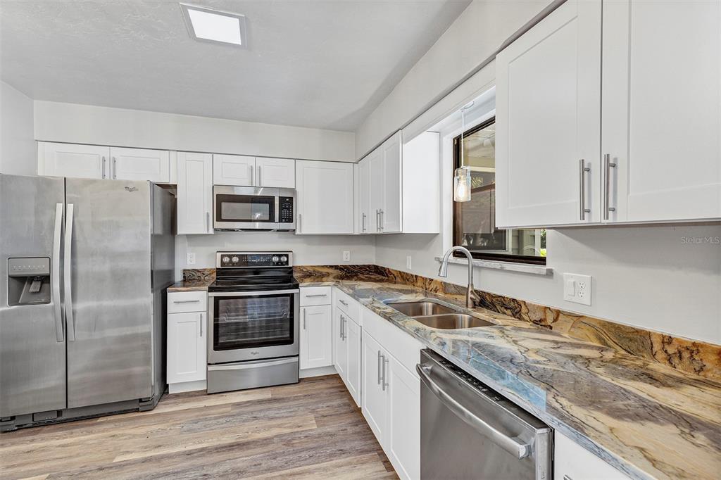 309 Southwest 77th Terrace Gainesville, FL 32607 - Photo 30 of 59 a kitchen with stainless steel appliances granite countertop a stove a sink dishwasher a refrigerator and a microwave oven