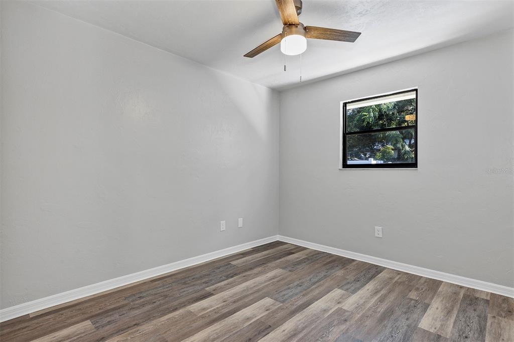 309 Southwest 77th Terrace Gainesville, FL 32607 - Photo 32 of 59 an empty room with wooden floor and ceiling fan