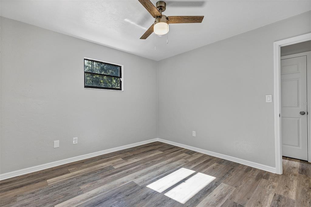 309 Southwest 77th Terrace Gainesville, FL 32607 - Photo 37 of 59 an empty room with wooden floor and windows