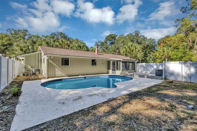 an aerial view of a house with swimming pool and lake view