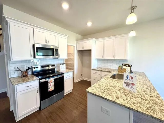 a kitchen with a sink refrigerator and microwave