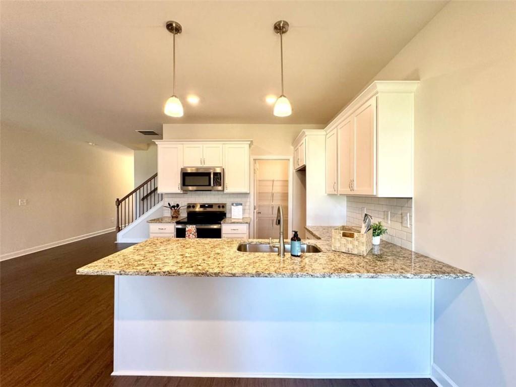 6346 Pine Ridge Point Lula, GA 30554 - Photo 13 of 26 a view of a kitchen with kitchen island a counter top space appliances and a center island