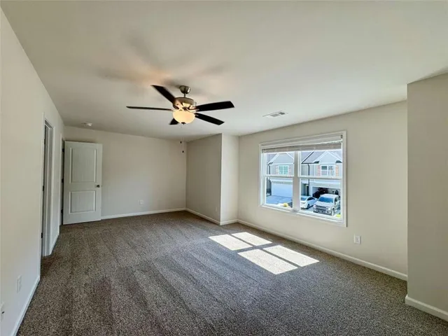 a spacious bathroom with a granite countertop double vanity and a mirror