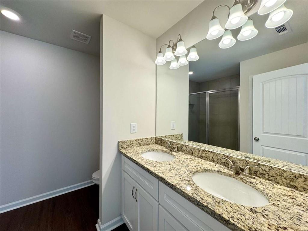 6346 Pine Ridge Point Lula, GA 30554 - Photo 19 of 26 a spacious bathroom with a granite countertop double vanity and a mirror