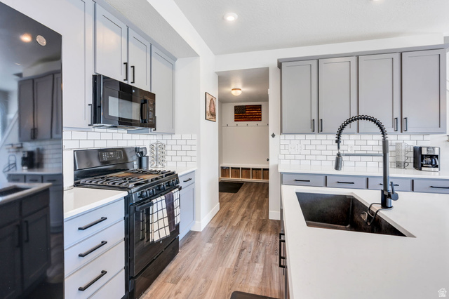 252 North Sunrise Rnch Drive Mapleton, UT 84664 - Photo 19 of 62 Modern kitchen featuring light gray cabinetry, white subway tile backsplash, white countertops, and wood-finish flooring