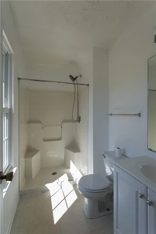 a bathroom with a toilet and a shower