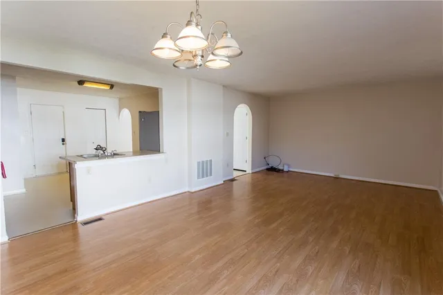 a view of a kitchen with wooden floor and a sink