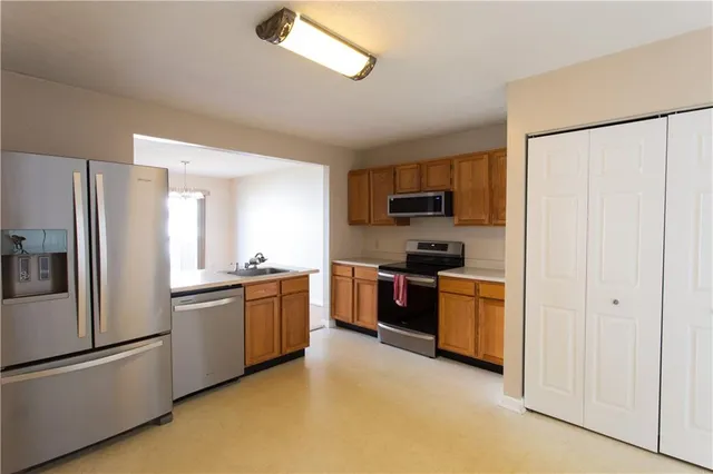 a kitchen with stainless steel appliances granite countertop a refrigerator a stove top oven a sink and dishwasher