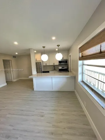 a large room with a large window and stainless steel appliances