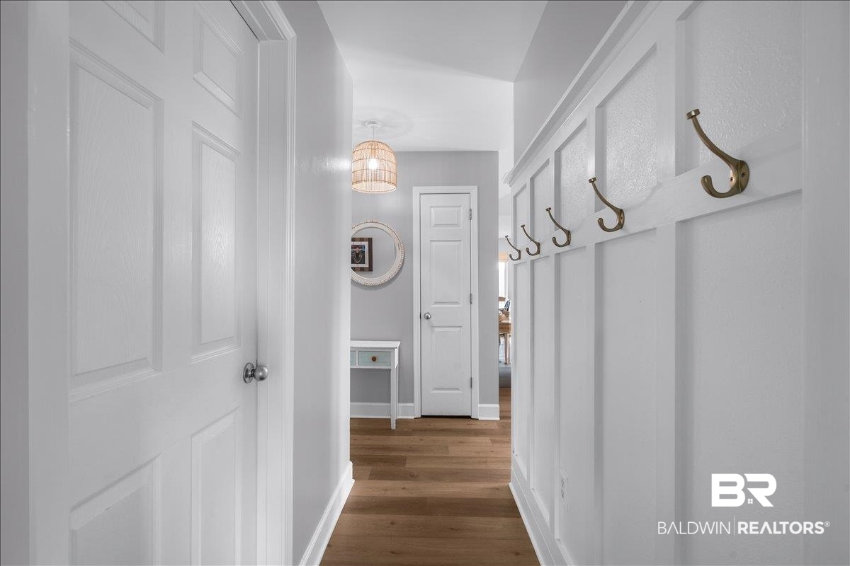 8952 Sherman Road Foley, AL 36535 - Photo 30 of 41 Hallway featuring board-and-batten wall detailing, wood-finish flooring, and white panel doors