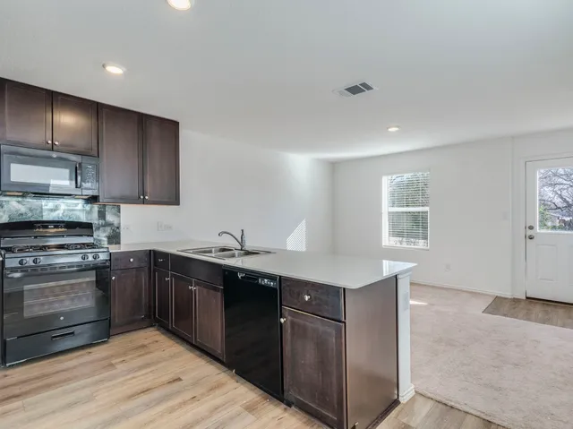 a kitchen with a sink stove and cabinets