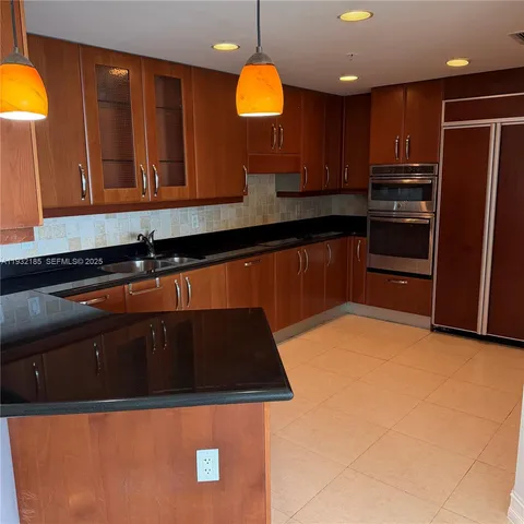 a kitchen with stainless steel appliances granite countertop a sink a stove and a refrigerator