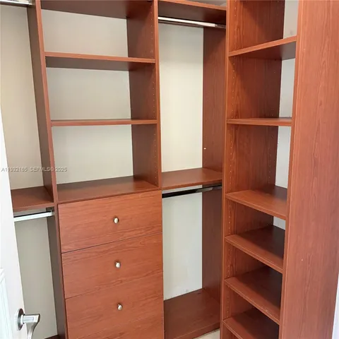 a view of walk in closet with empty racks