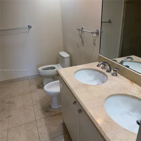 a bathroom with a granite countertop sink a toilet and a mirror