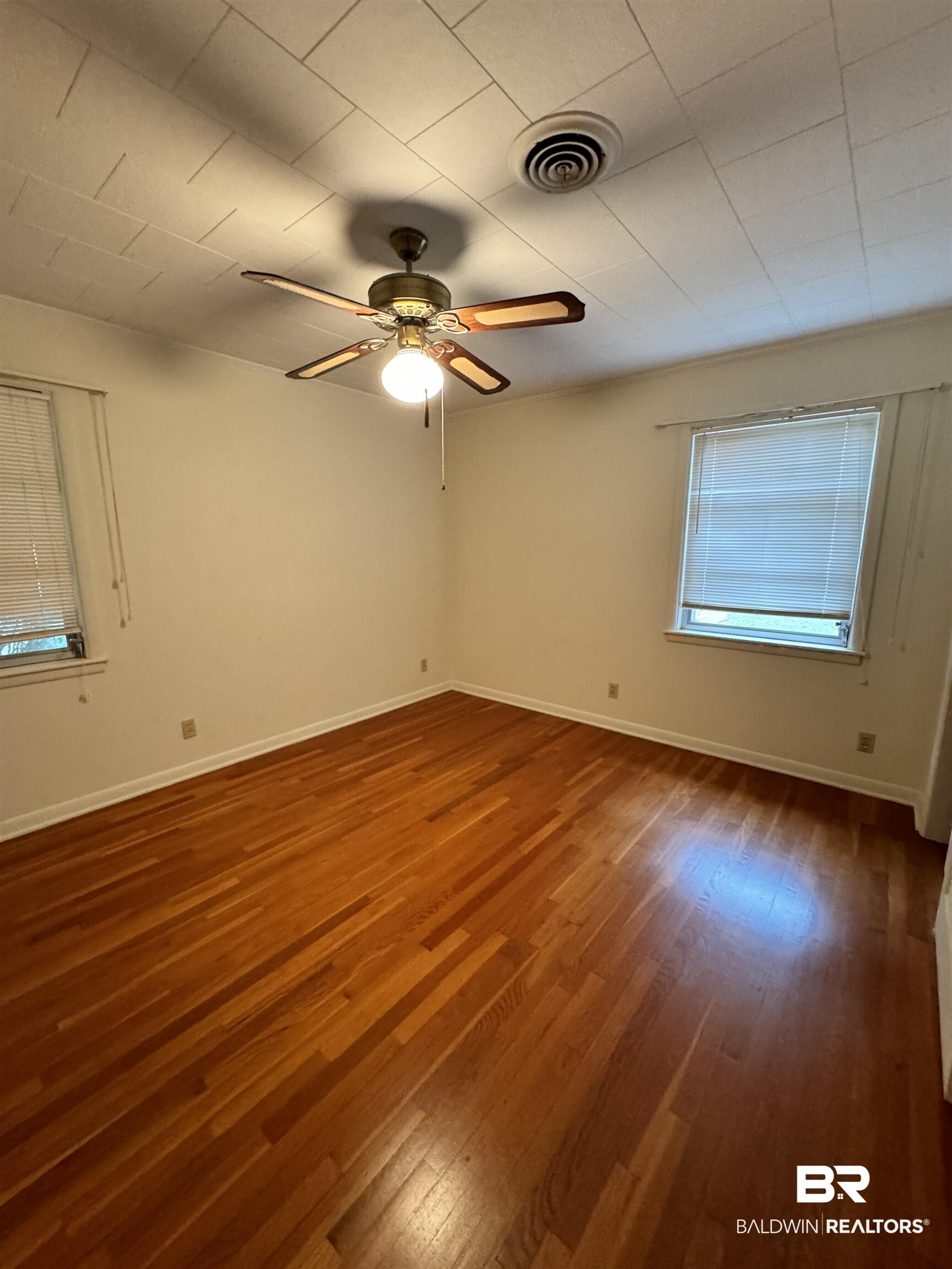 217 West Magnolia Avenue Foley, AL 36535 - Photo 13 of 21 Empty room featuring hardwood / wood-style floors and ceiling fan