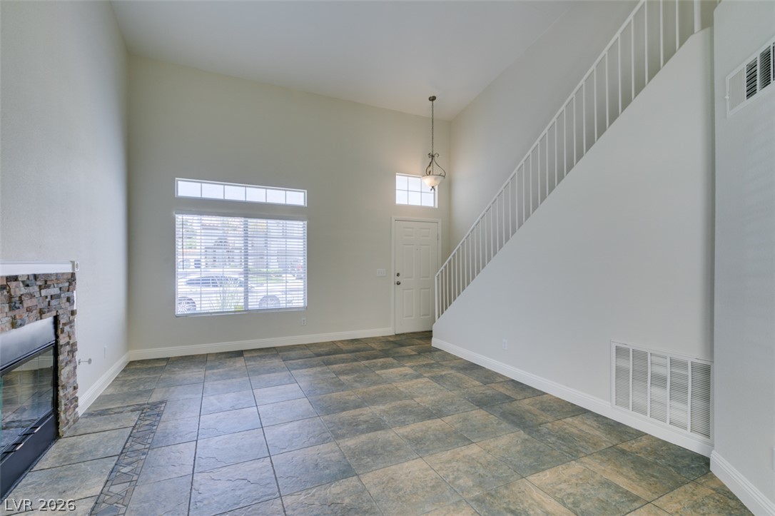 200 Luninborg Street Henderson, NV 89074 - Photo 19 of 40 A spacious living area featuring a stone-faced fireplace and striking vaulted ceilings.