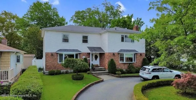 a front view of a house with a garden and plants