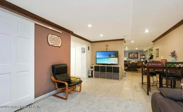a living room with furniture a flat screen tv and kitchen view