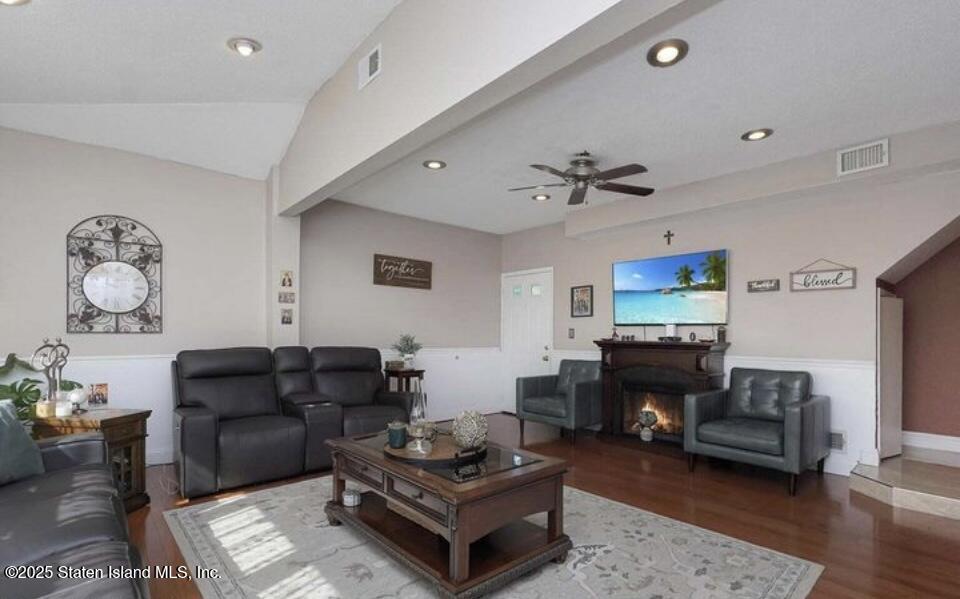 160 Rathbun Avenue Staten Island, NY 10312 - Photo 10 of 37 a living room with furniture a fireplace and a flat screen tv