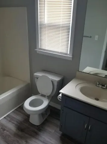 a bathroom with a toilet sink and mirror