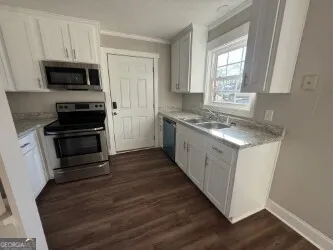 a kitchen with a stove a sink and a microwave
