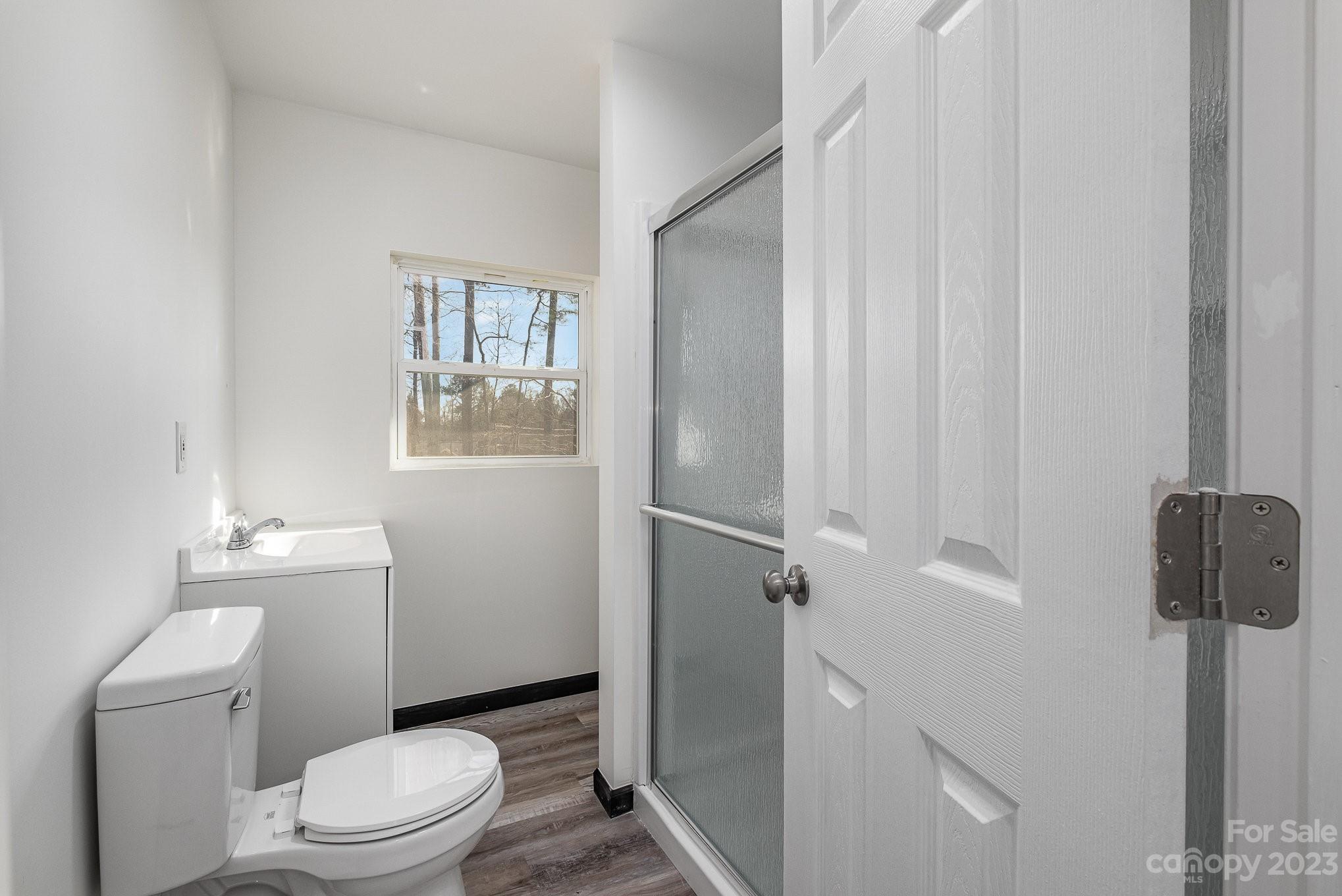 6922 Pear Tree Road Charlotte, NC 28216 - Photo 17 of 26 a white toilet sitting next to a bathroom sink and vanity