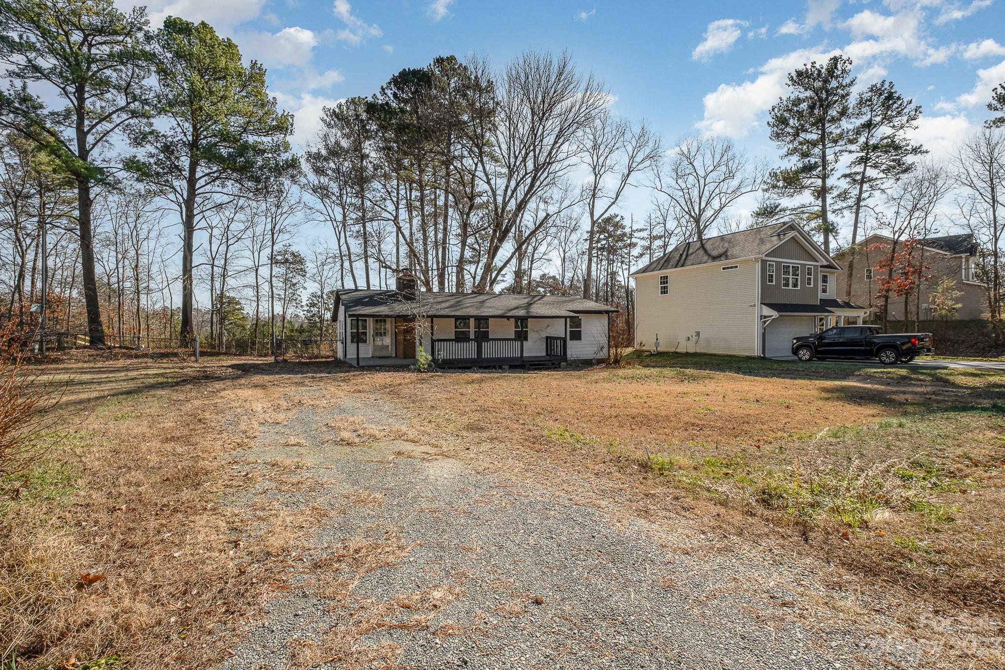 6922 Pear Tree Road Charlotte, NC 28216 - Photo 3 of 26 a view of a white house with a yard covered with snow in the yard