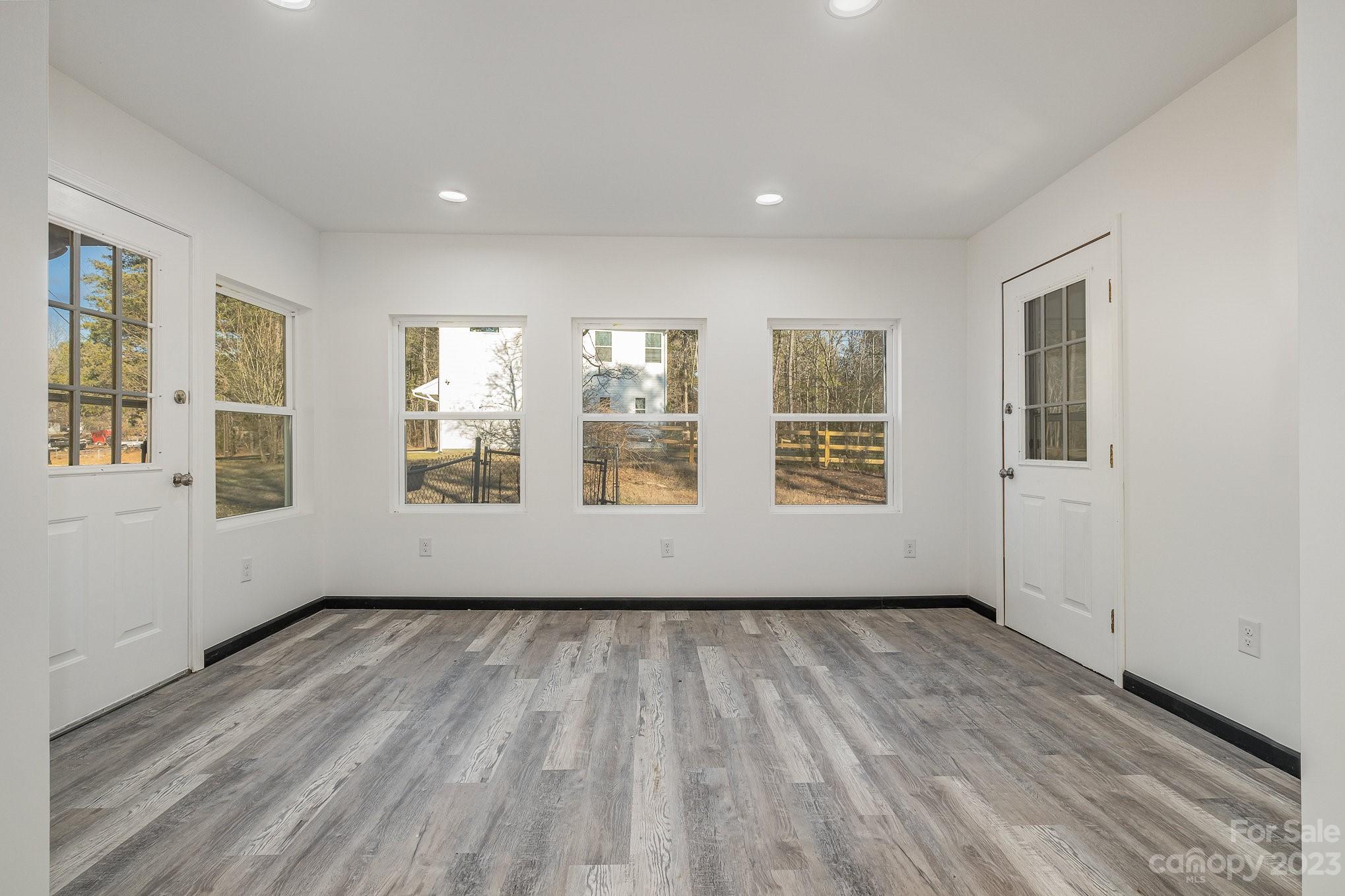 6922 Pear Tree Road Charlotte, NC 28216 - Photo 6 of 26 a view of an empty room with wooden floor and windows