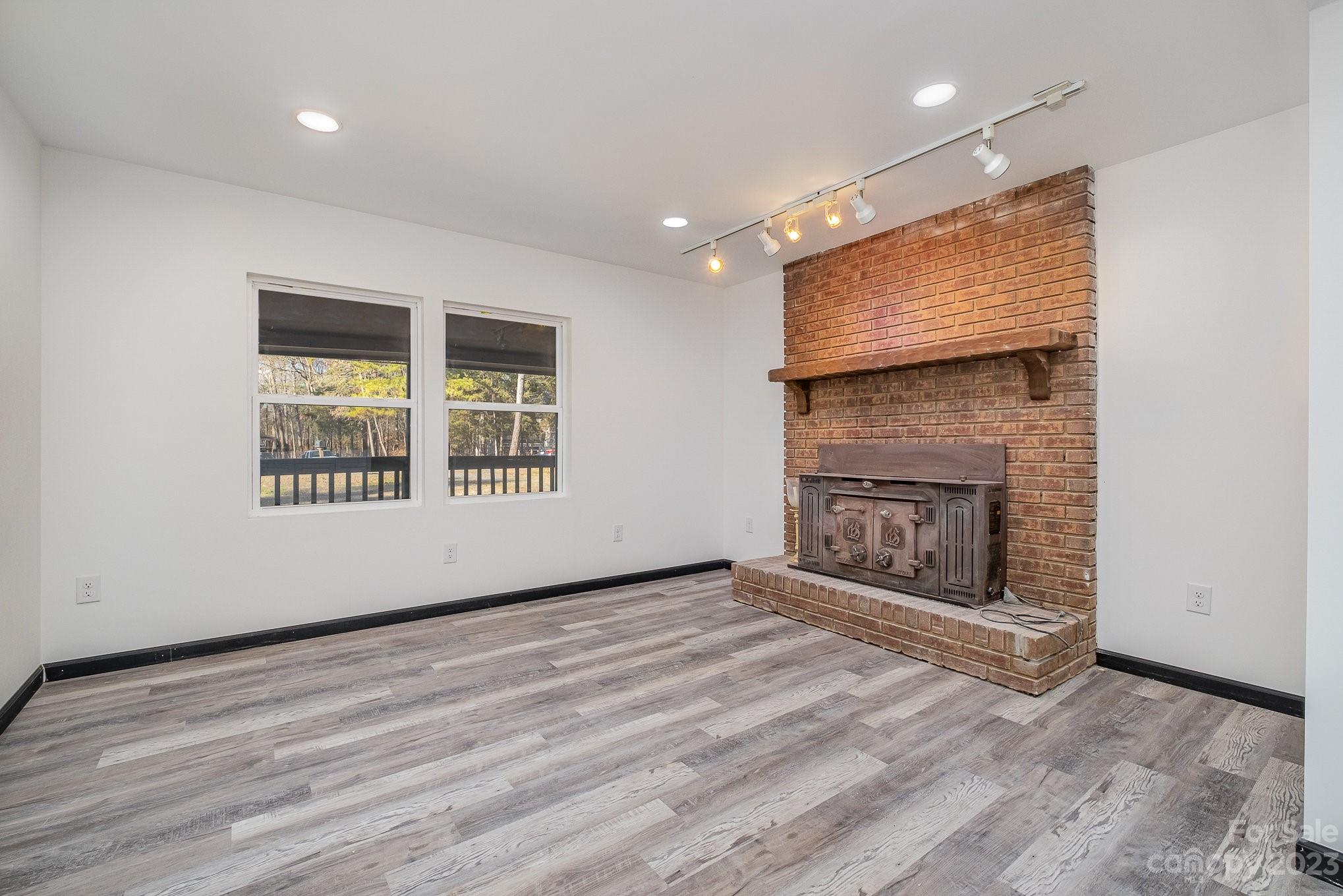 6922 Pear Tree Road Charlotte, NC 28216 - Photo 10 of 26 an empty room with windows and fireplace
