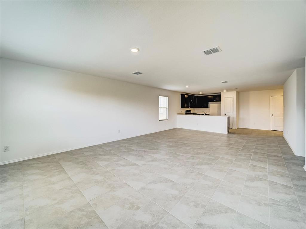 357 Sun Bluff Road Fort Worth, TX 76052 - Photo 33 of 35 Expansive open concept room featuring large format tile flooring, recessed ceiling lighting, and a kitchen area with dark cabinetry and a breakfast bar