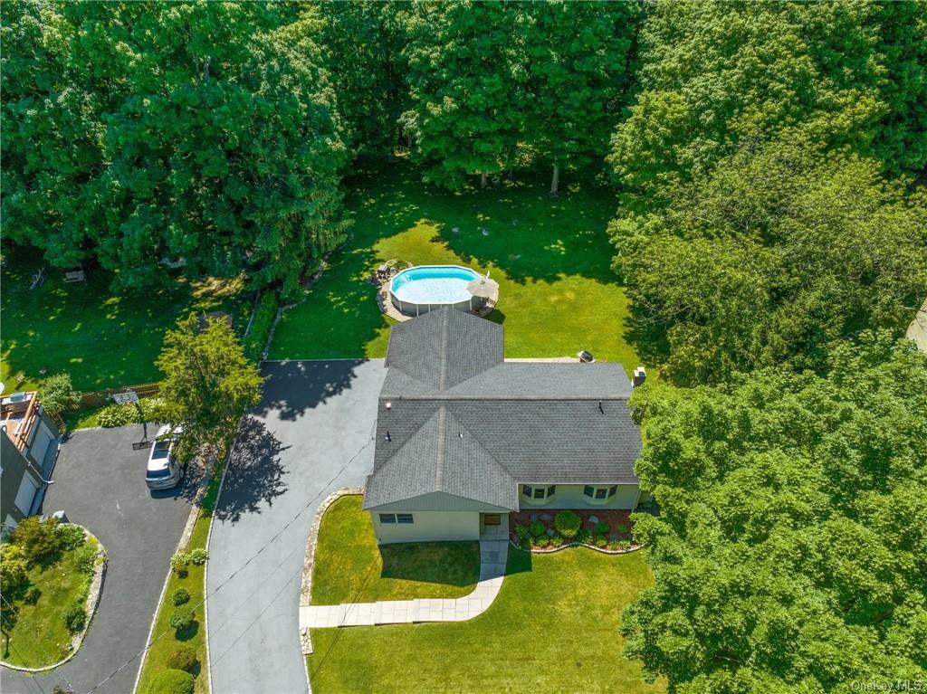 an aerial view of a house with swimming pool and yard