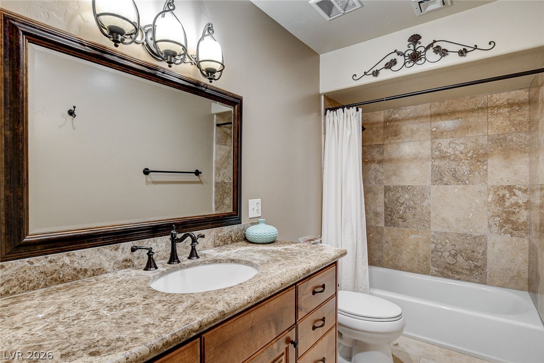 1950 Bowman Road Logandale, NV 89021 - Photo 14 of 98 A well-appointed bathroom features a single vanity with a marble countertop and a tiled shower-tub combination.