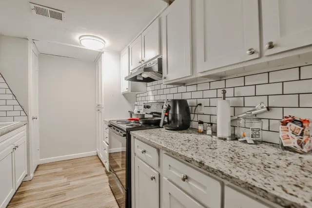 a kitchen with stainless steel appliances granite countertop a sink stove and cabinets