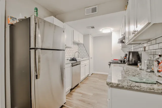 a kitchen with granite countertop a refrigerator and a sink