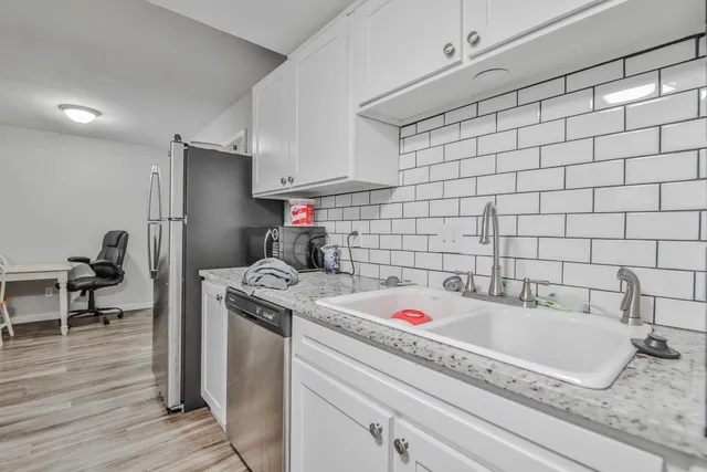 a kitchen with a sink a stove and cabinets