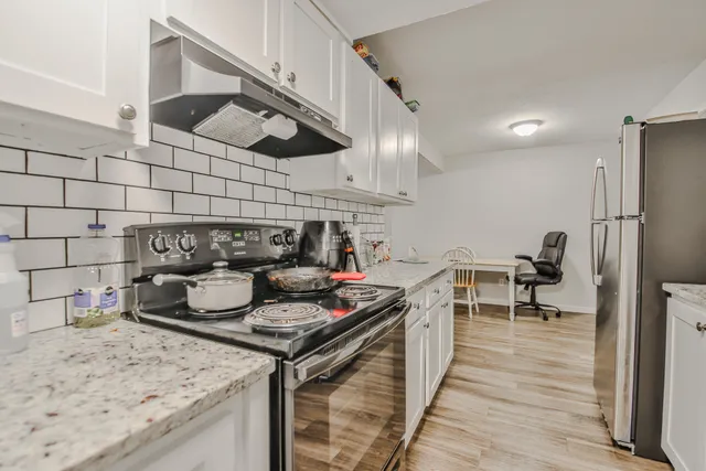 a kitchen with stainless steel appliances granite countertop a stove and a wooden cabinets