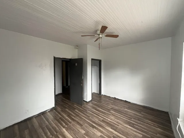 a view of empty room with wooden floor