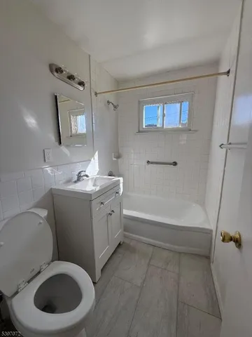 a bathroom with a granite countertop toilet sink and mirror