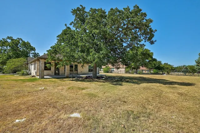 a view of a house with a yard and sitting area