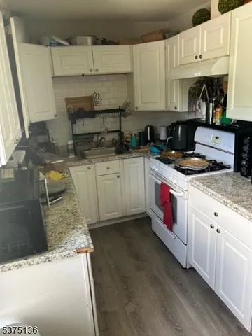 a kitchen with stainless steel appliances granite countertop a sink stove and cabinets